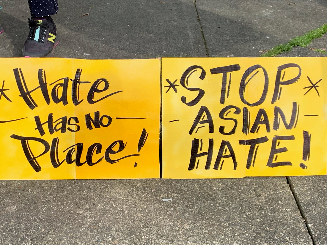 Yellow sign with Hate Has No Place and Stop Asian Hate written on it