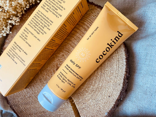 cocokind SPF lotion on top of wooden block 