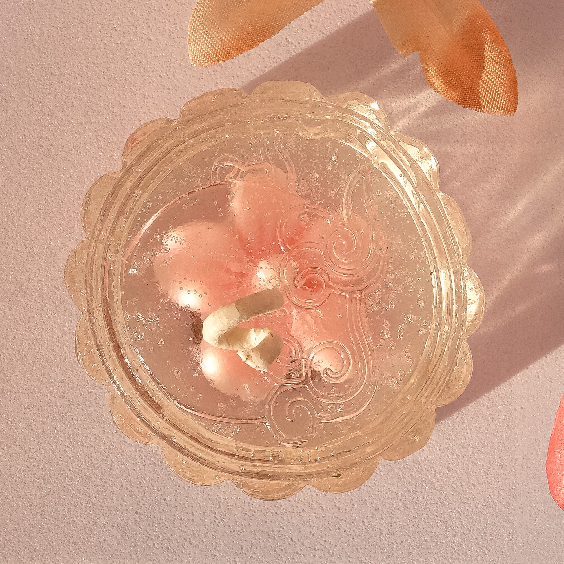 clear mooncake candle on a pink background 
